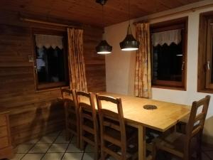 ein Esszimmer mit einem Holztisch und Stühlen in der Unterkunft Le Tchou in Bonneval-sur-Arc