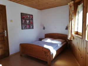 ein Schlafzimmer mit einem Holzbett in einem Zimmer in der Unterkunft Le Tchou in Bonneval-sur-Arc