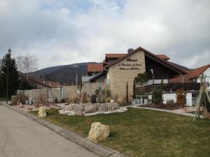 un edificio con un patio con rocas delante de él en Weinhotel Kienle en Burrweiler