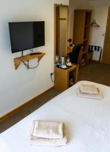 a bedroom with a large white bed with two towels at The Windmill Inn in Watchet