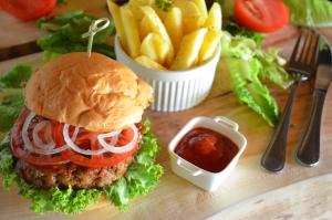 a hamburger and french fries on a table at Tava Lingwe Game Lodge & Wedding Venue in Parys