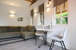 sala de estar con sofá, mesa y sillas en Chalet Santpoort-Zuid, en Santpoort-Zuid