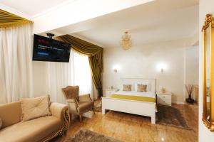 um quarto com uma cama, um sofá e uma televisão em Hotel Evianne Boutique em Galaţi