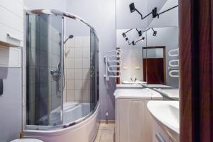 a bathroom with a shower and two sinks at Mrówka in Kraków