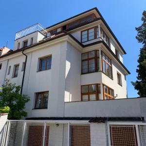 Cette grande maison blanche possède de nombreuses fenêtres. dans l'établissement NEW Apartment Penthouse, à Prague