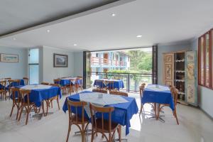uma sala de jantar com mesas e cadeiras azuis em Pousada da Chácara em Mariana