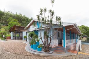 uma casa com palmeiras em frente em Pousada da Chácara em Mariana
