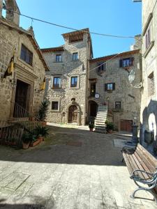 una panchina seduta di fronte a un edificio in pietra di B&B Il Grifo a Bomarzo