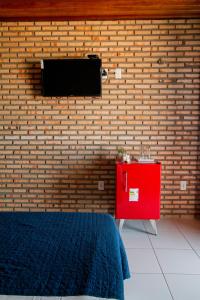 una camera con un muro di mattoni e un comò rosso di Pousada Dona Santinha a Trairi