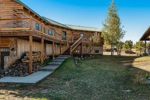 a log cabin with stairs leading up to a house at Snow Circle Lodge in Pagosa Springs