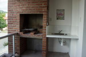 a kitchen with a brick fireplace with a sink at El Fortín 95 Alquiler temporario in San Salvador de Jujuy