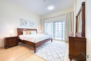 a bedroom with a bed and a balcony at Cozy 1BR in the Olympic Park, Sport City by Deluxe Holiday Homes in Dubai