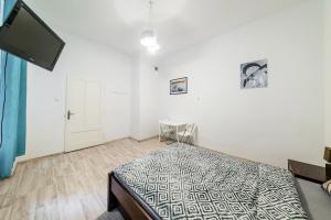 um quarto com uma cama e uma televisão de ecrã plano em Coco apartment 1 na Cracóvia