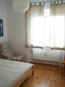 a bedroom with a bed and a window and a chair at Bright Side Apartment Koszutka in Katowice