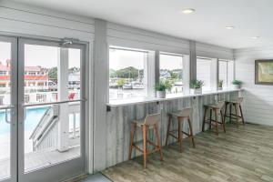 a bar with stools in a room with windows at Shem Creek Inn in Charleston