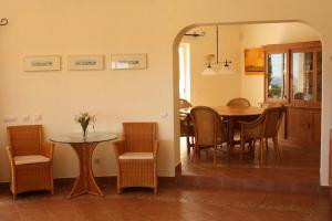 Villa with beautiful see views & spacious garden في فيريغودو: غرفة طعام ومطبخ مع طاولة وكراسي