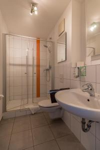 a bathroom with a sink and a shower and a toilet at Hotel am Brauerei-Dreieck in Bamberg
