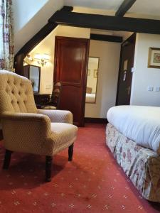 a hotel room with a bed and a chair and a bedroom at Stow Lodge Hotel in Stow on the Wold