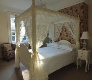 a bedroom with a white bed with a canopy at Hedgefield House in Gateshead