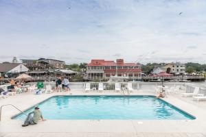 um homem sentado ao lado de uma piscina em Shem Creek Inn em Charleston