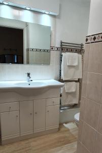 a bathroom with a sink and a toilet and a mirror at Stow Lodge Hotel in Stow on the Wold