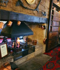 a room with a stove with a fire in it at Stow Lodge Hotel in Stow on the Wold