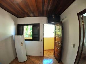an empty room with a refrigerator and a door at Pousada Recanto Itaguá in Ubatuba