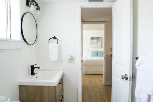 a white bathroom with a sink and a mirror at Molloy Gulf Motel & Cottages in St. Pete Beach