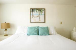 a bedroom with a bed with white sheets and palm trees at Molloy Gulf Motel & Cottages in St Pete Beach