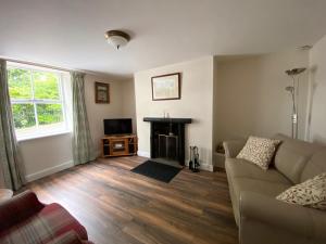 sala de estar con sofá y chimenea en Bondgate Holiday Cottage en Durham