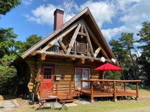 een blokhut met een rode deur bij Ise Forest villa - Vacation STAY 9557 in Ise
