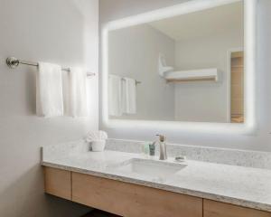 La salle de bains est pourvue d'un lavabo et d'un grand miroir. dans l'établissement Hallmark Resort - Newport, à Newport