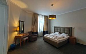 a bedroom with a bed and a desk and a mirror at Kamienica Bankowa Residence in Poznań