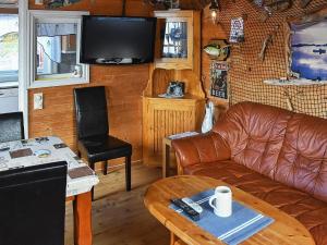 sala de estar con sofá de cuero y TV en 6 person holiday home in Oksvoll, en Oksvoll