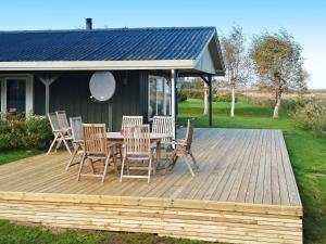eine Holzterrasse mit einem Tisch und Stühlen darauf in der Unterkunft 6 person holiday home in Hadsund in Hadsund