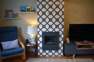 a living room with a fireplace and a tv at 5a Bank Street in Keswick