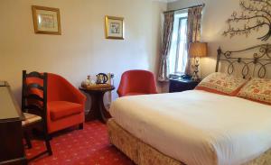 a hotel room with a bed and a chair at Stow Lodge Hotel in Stow on the Wold