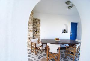 a dining room with a wooden table and chairs at Windmill Studios in Livadi