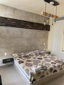 a bedroom with a bed with a floral bedspread at Hotel Morelos Colima in Colima