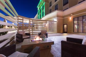 a patio with a fire pit and chairs and a building at Holiday Inn Texarkana Arkansas Convention Center by IHG in Texarkana
