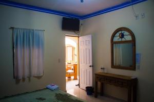 een slaapkamer met een spiegel en een klok aan de muur bij Hotel Morelos Colima in Colima