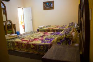 a bedroom with two beds with a colorful comforter at Hotel Morelos Colima in Colima