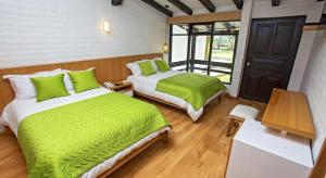 1 dormitorio con 2 camas con sábanas verdes en Hosteria Totoral, en Ibarra