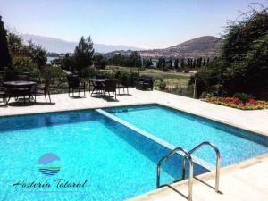 a large swimming pool with a table and chairs at Hosteria Totoral in Ibarra