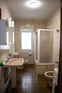 een badkamer met een wastafel en een toilet en een raam bij Apartamento PLAYA ESTEIRO in Muros +20 foto's