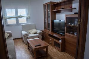 een woonkamer met een stoel en een televisie bij Apartamento PLAYA ESTEIRO in Muros