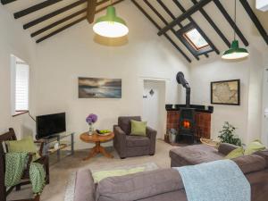 a living room with a couch and a fireplace at Glan Aber in Amlwch