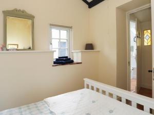 1 dormitorio con cama y espejo en la pared en Glan Aber, en Amlwch