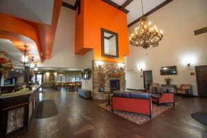 a large living room with a stone fireplace at Best Western PLUS Cimarron Hotel & Suites in Stillwater