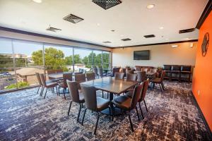 einen Konferenzraum mit Tischen und Stühlen und einem großen Fenster in der Unterkunft Best Western PLUS Cimarron Hotel & Suites in Stillwater
